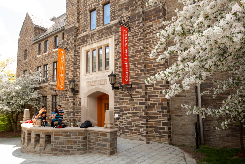 Cornell Law School banners hang on a building in spring