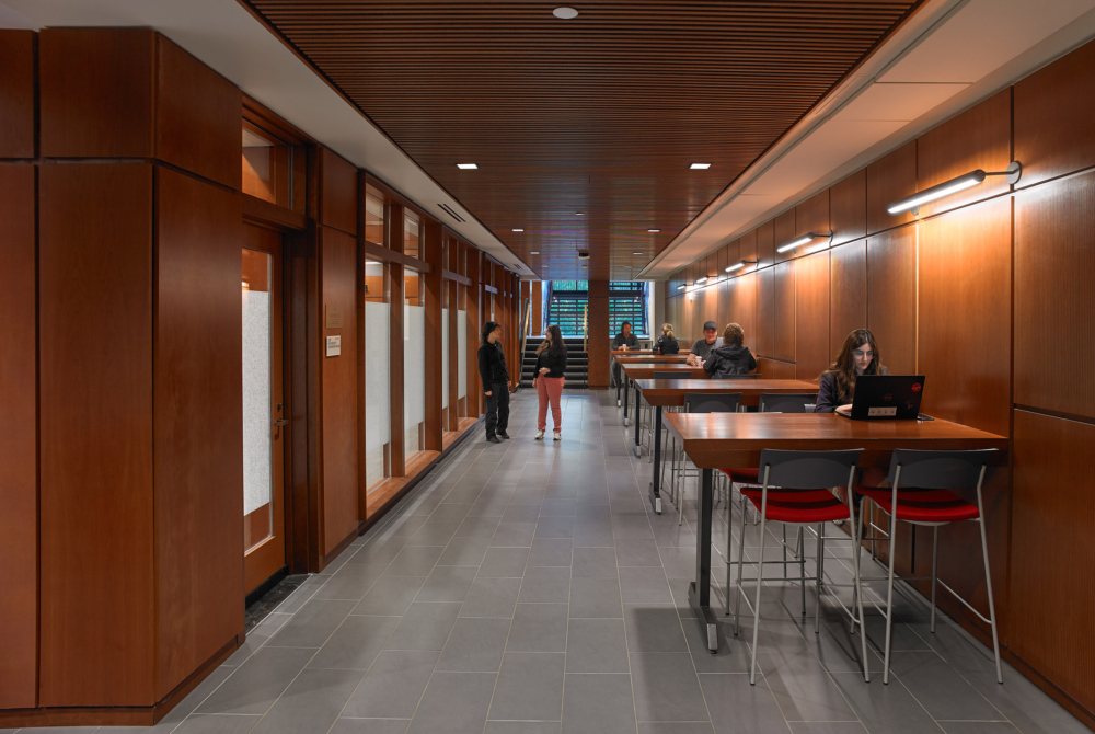 Small tables in a long hallway in an academic building