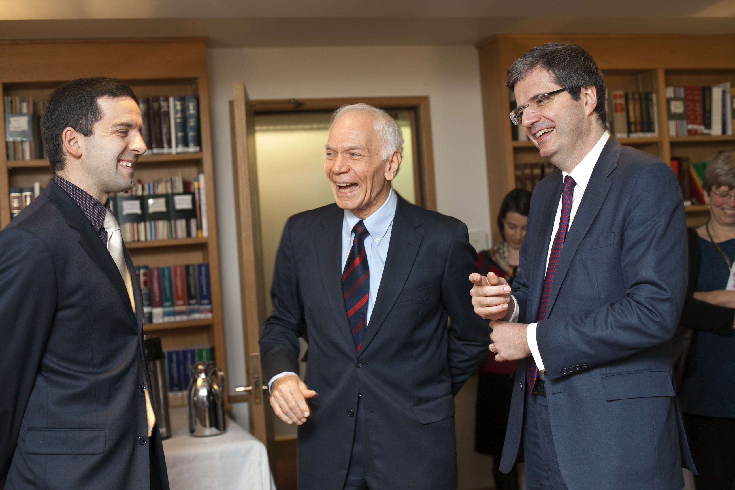 three men laughing in a library