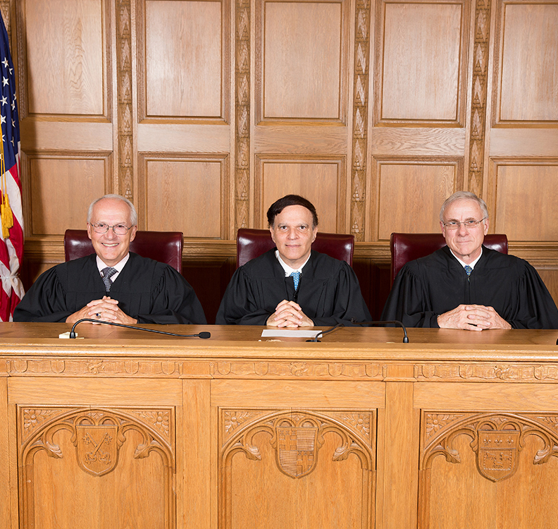 three judges sitting behind a trial bench