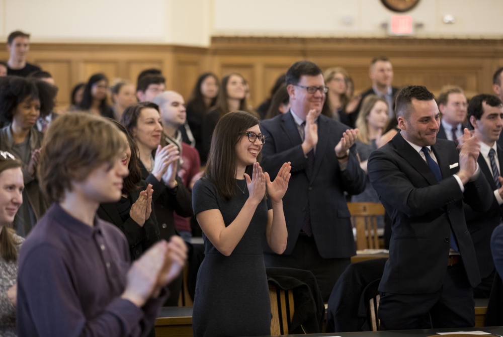 group of people standing and clapping