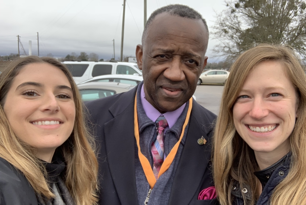 two young women and a man between