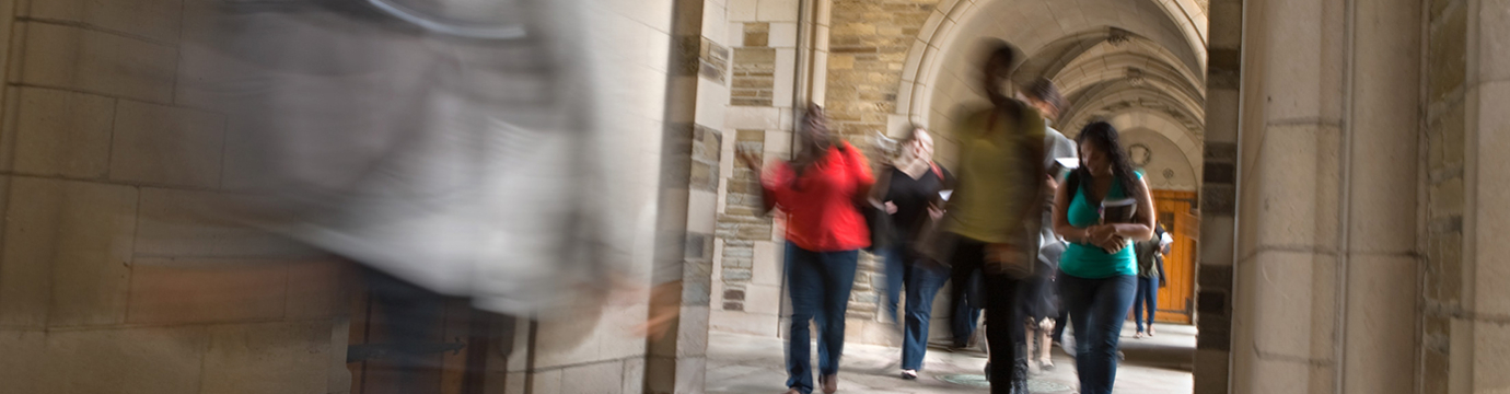 A group of law students walking under archway outside the building