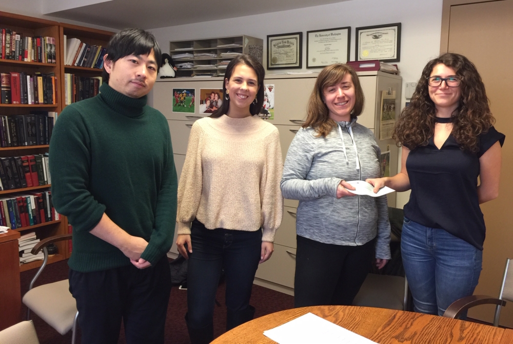 Masahiro Ueda, Carolyn Taglienti, and Rachel Horowitz deliver a check to their client after settling her termination case, which involved filing charges before the National Labor Relations Board related to her protected concerted activity.