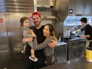 couple and child in a restaurant kitchen