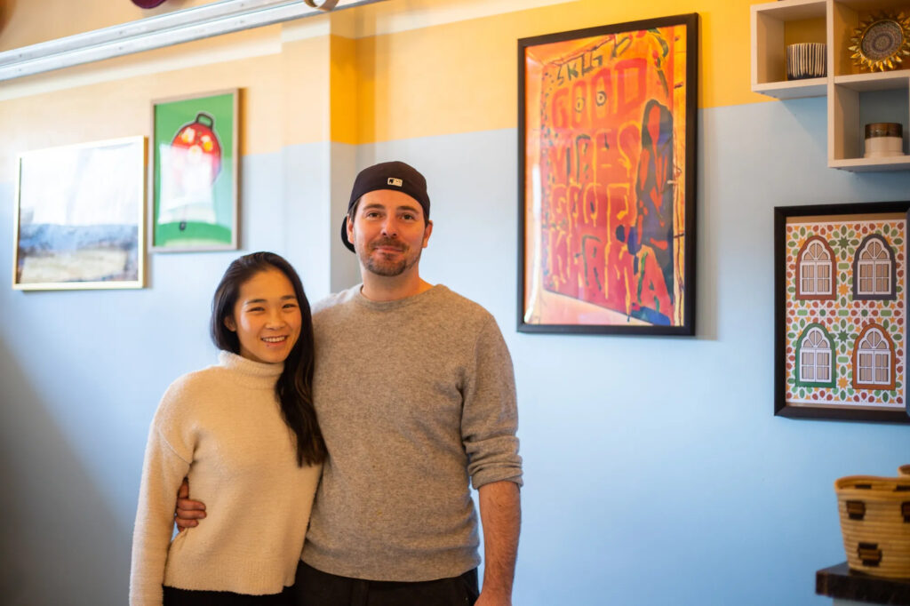 couple standing in front of a wall with art