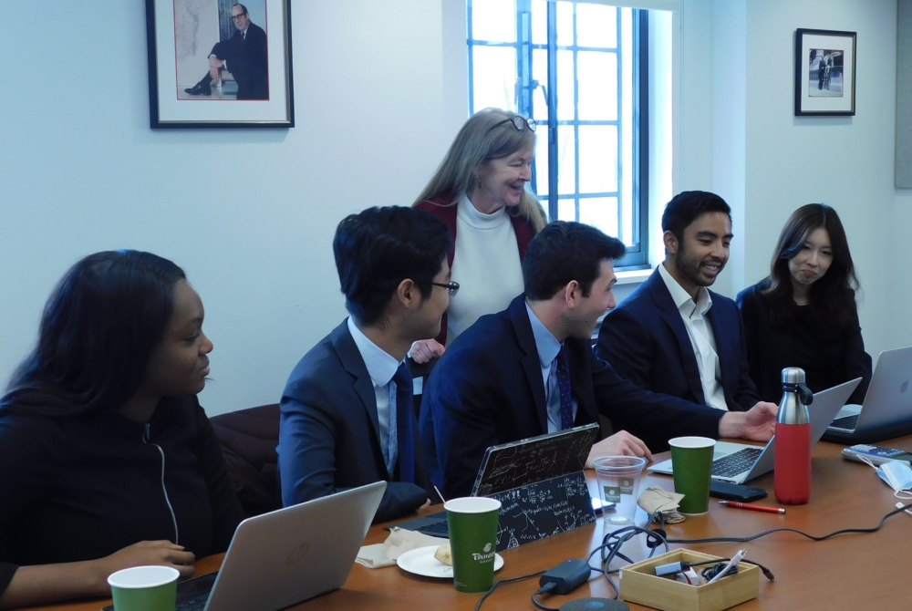 students and faculty member at a table