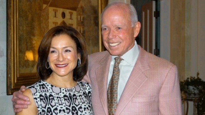 Photo of Franci J. Blassberg ’75, J.D. ’77, and Joseph L. Rice III standing with his arm around her. He wears a pink suit jacket and she wears a sleeveless patterned dress.