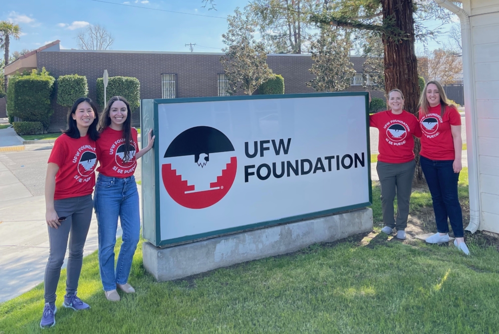 students wearing AFW shirts stand by the AFW Foundation sign