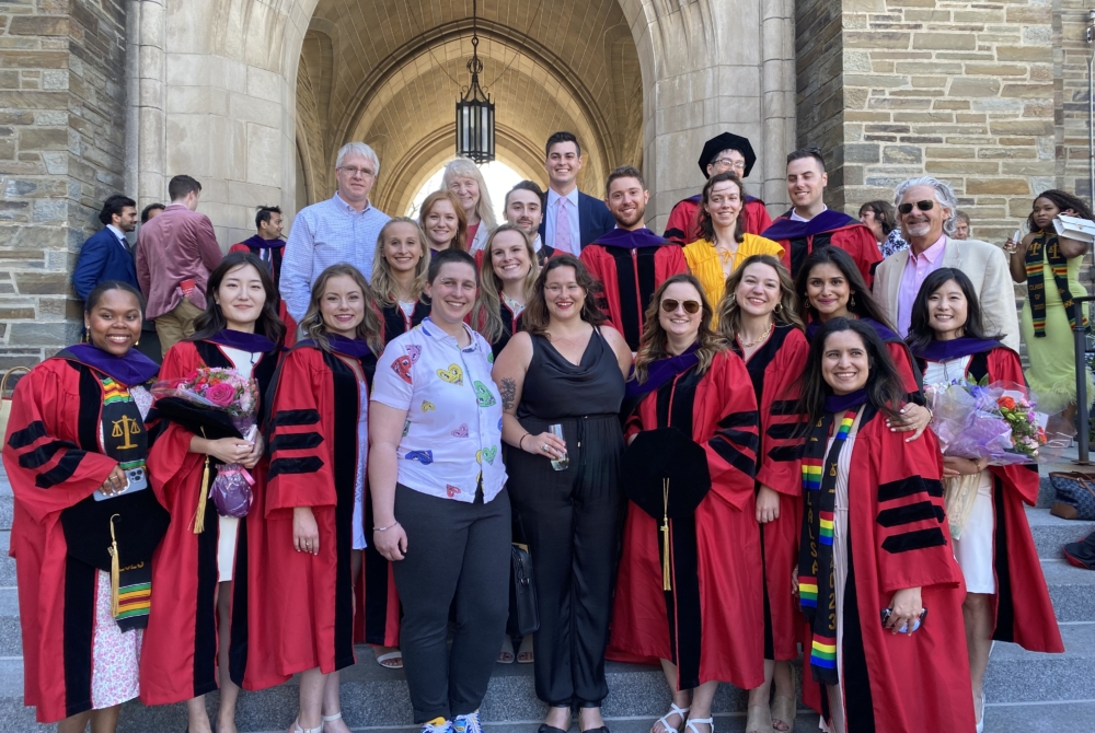 posed group of people, many in red graduation robes