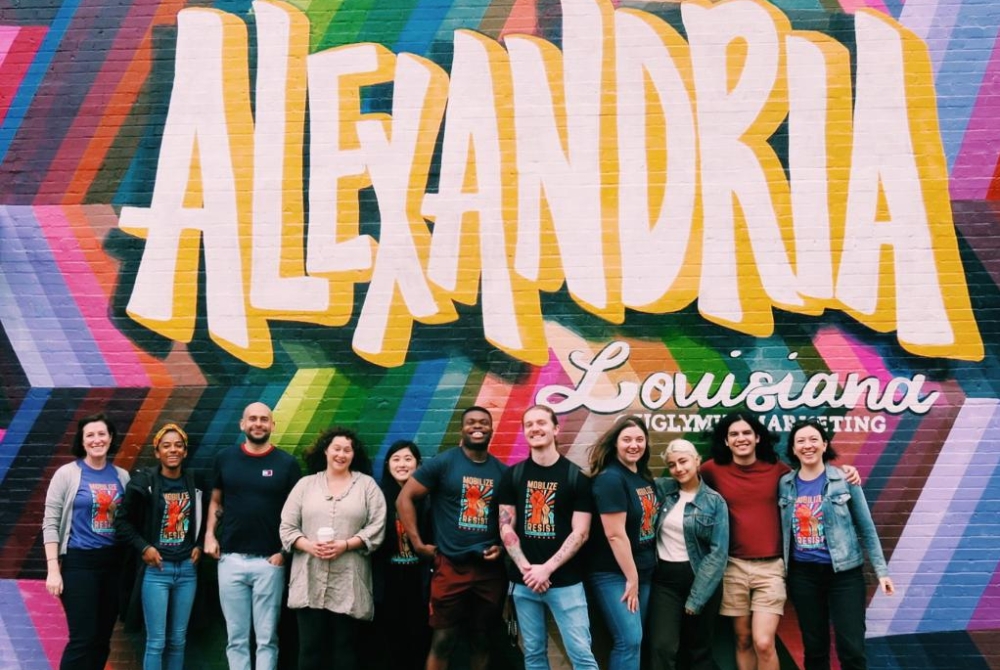 group of students in front of a colorful mural that says Alexandria Louisiana