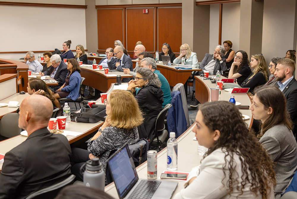 Wide view of all symposium attendees sitting and listening to a panel discussion.