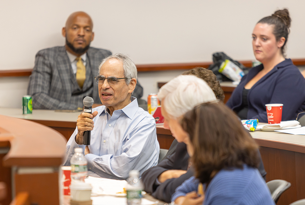 Symposium attendees ask questions during a panel discussion.