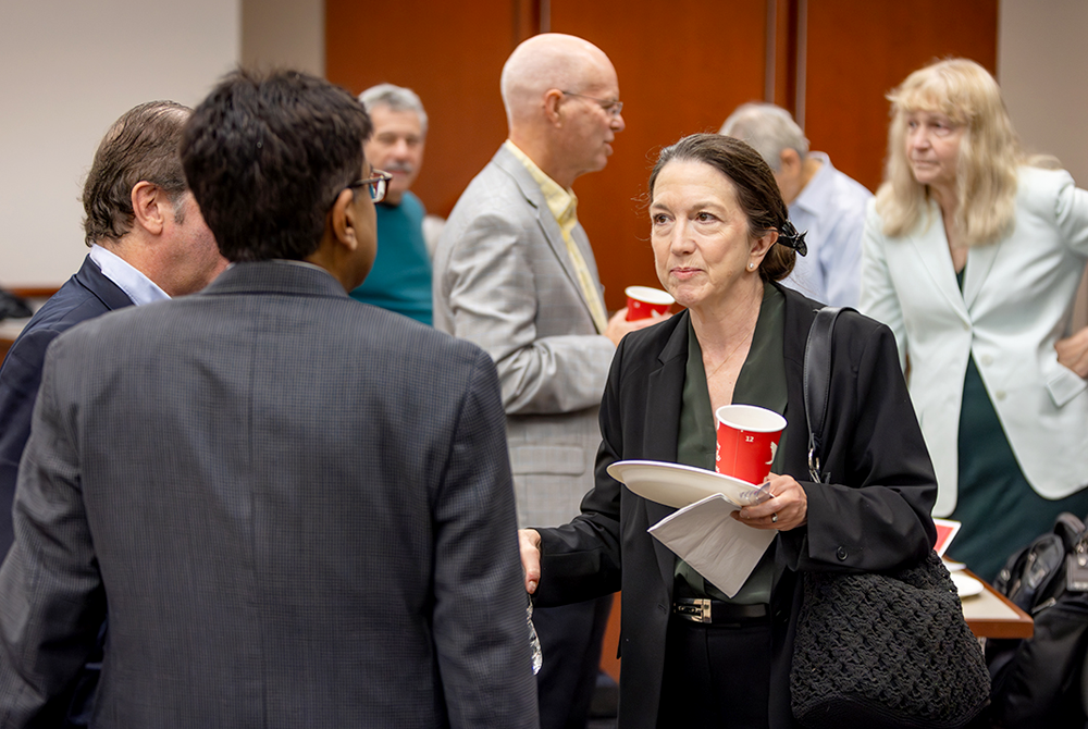 Seven attendees at event talking in-between panels.