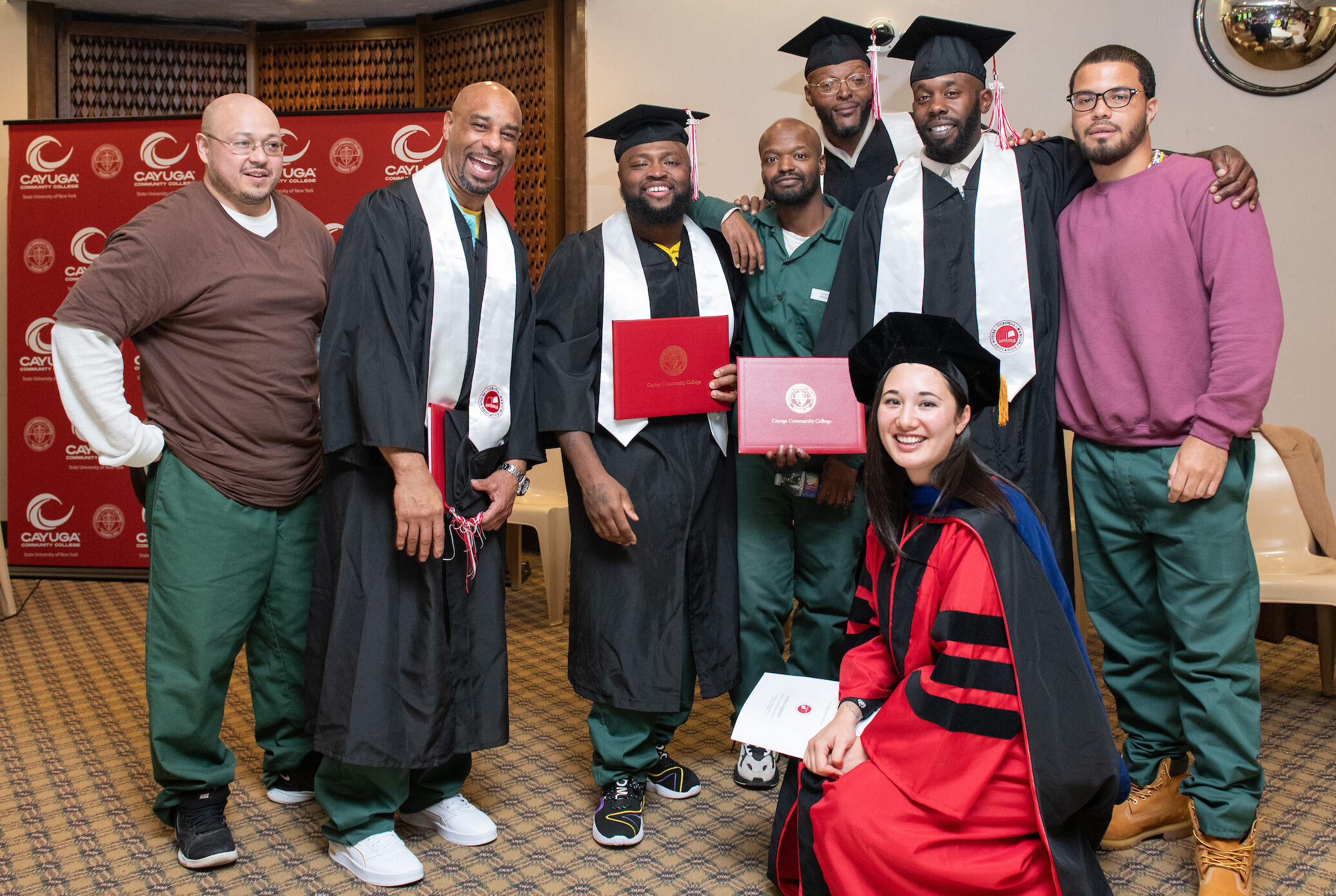 group of graduates with faculty member in regalia