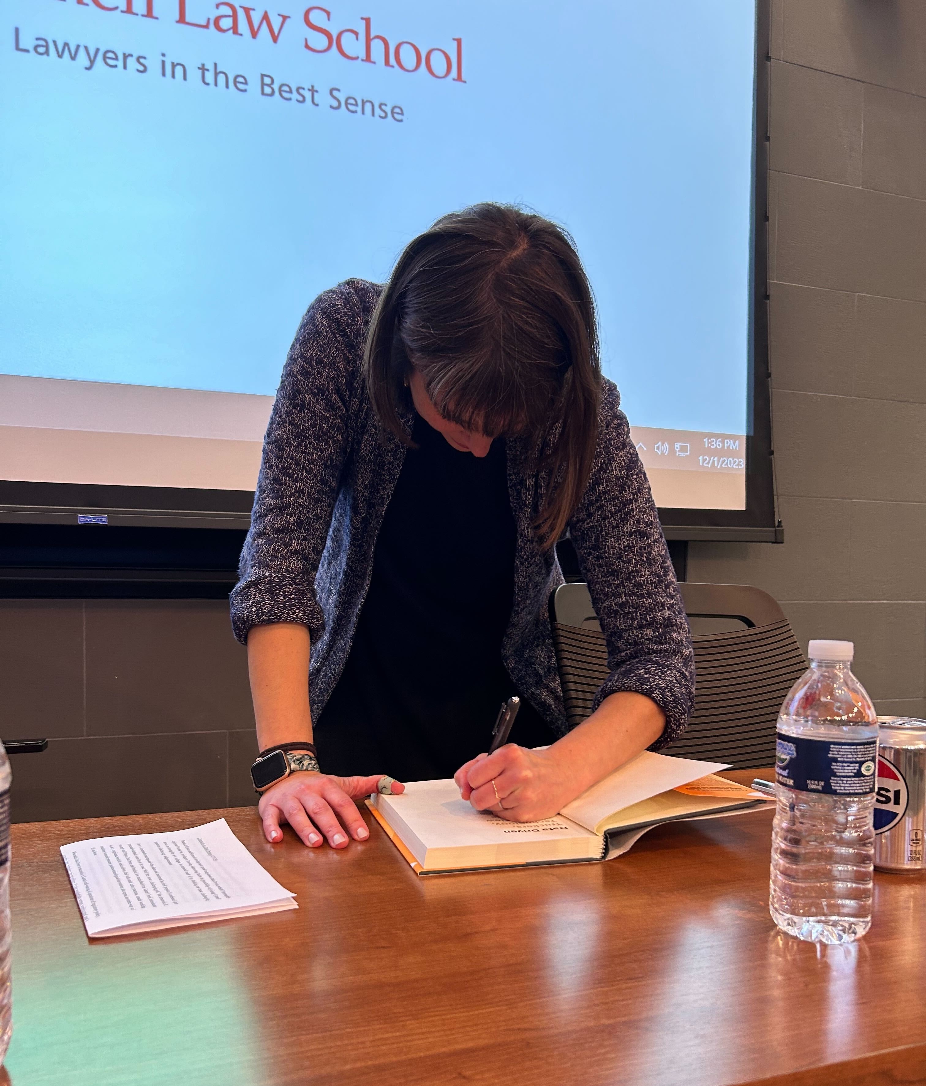 Professor Karen Levy signing a copy of her book for someone