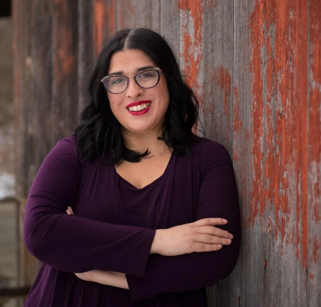 headshot of Sujata Gibson standing in front of a barn