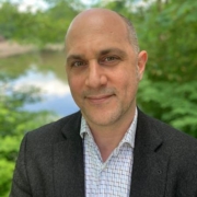 Jason Mokhtarian with green trees and lake in background.