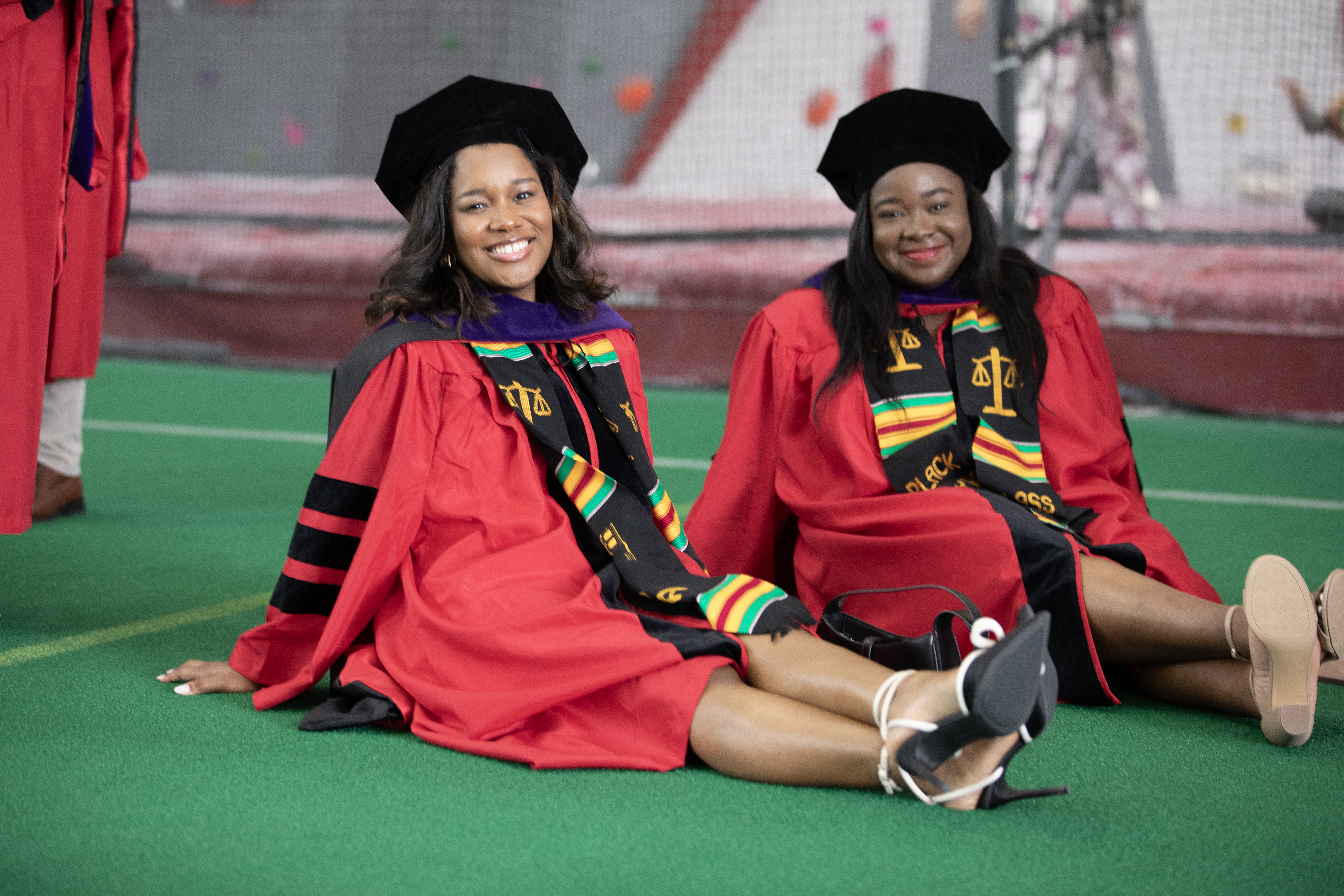 two students sitting down waiting for their line to be called out for the ceremony