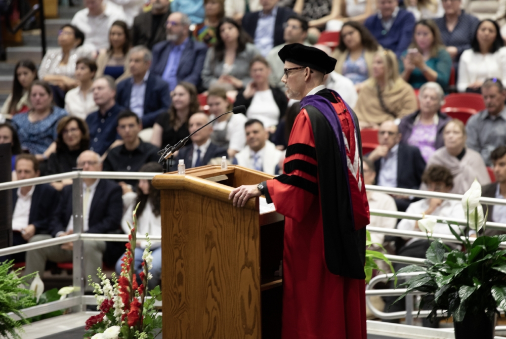 a faculty member addressing the crowd at the ceremony