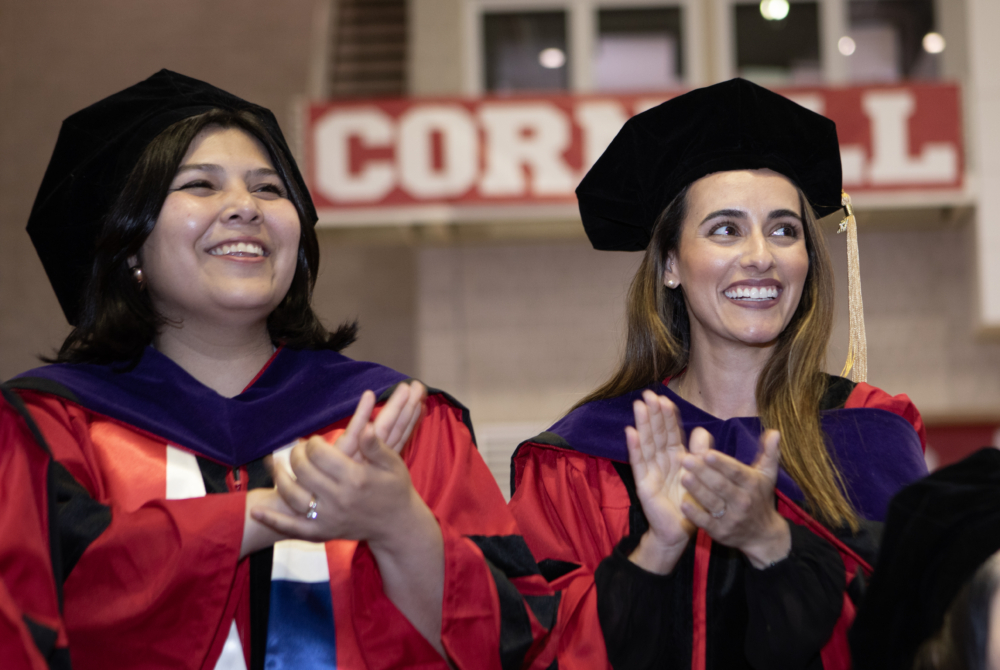 two students clapping at the ceremony