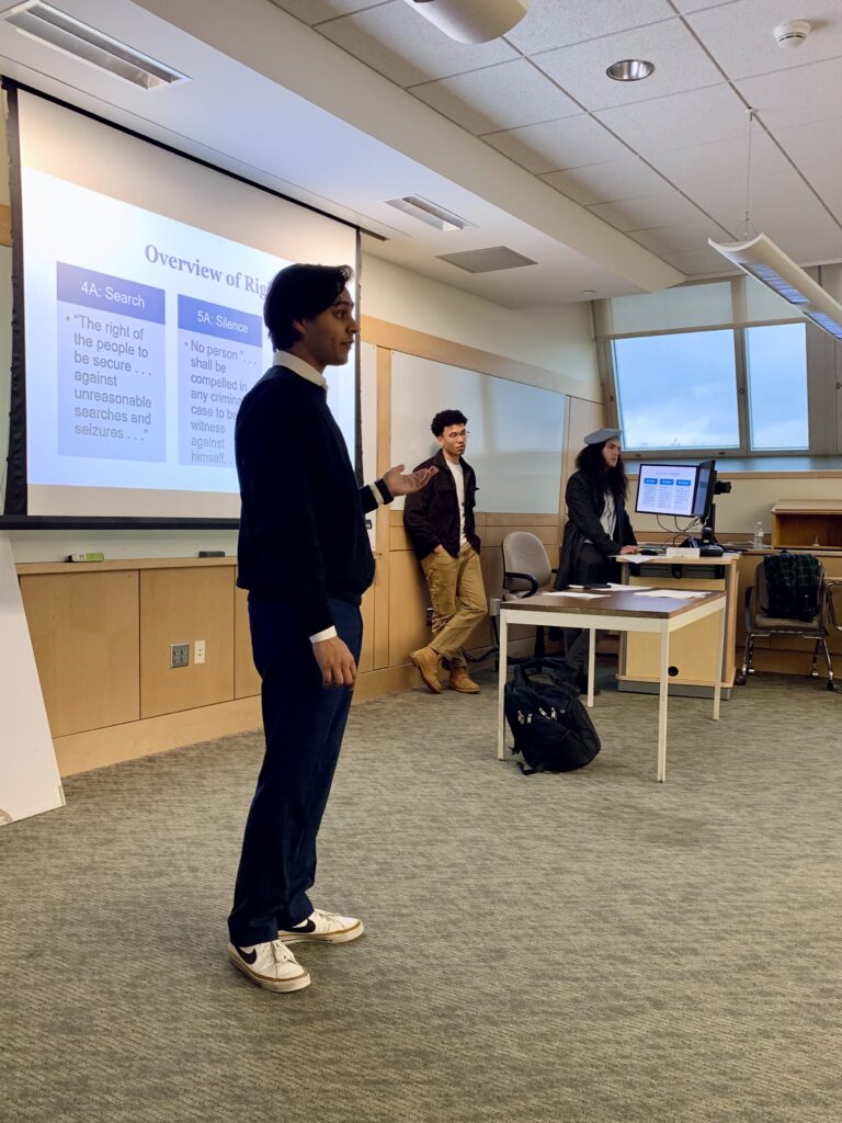 3 students presenting from a screen 