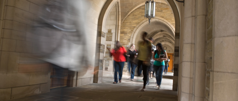 A group of law students walking under archway outside the building