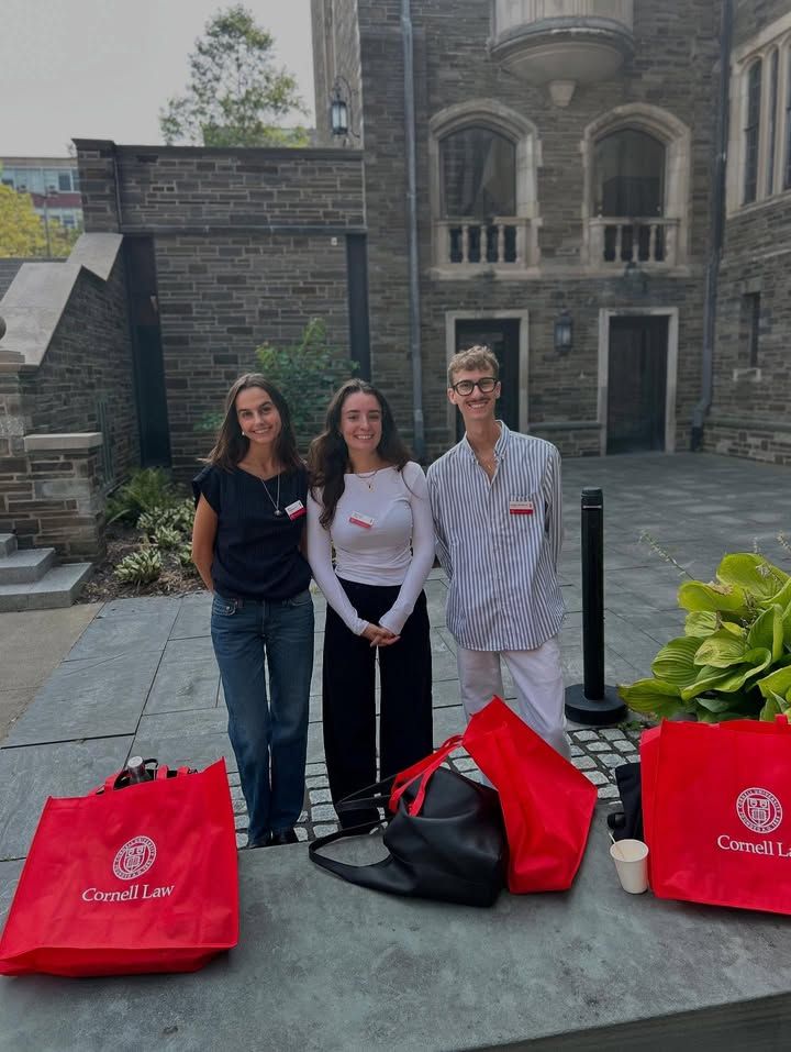3 llm students standing outside posing for photo in courtyard