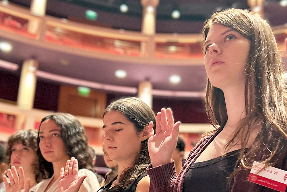 students reciting oath of professionalism with their hands up