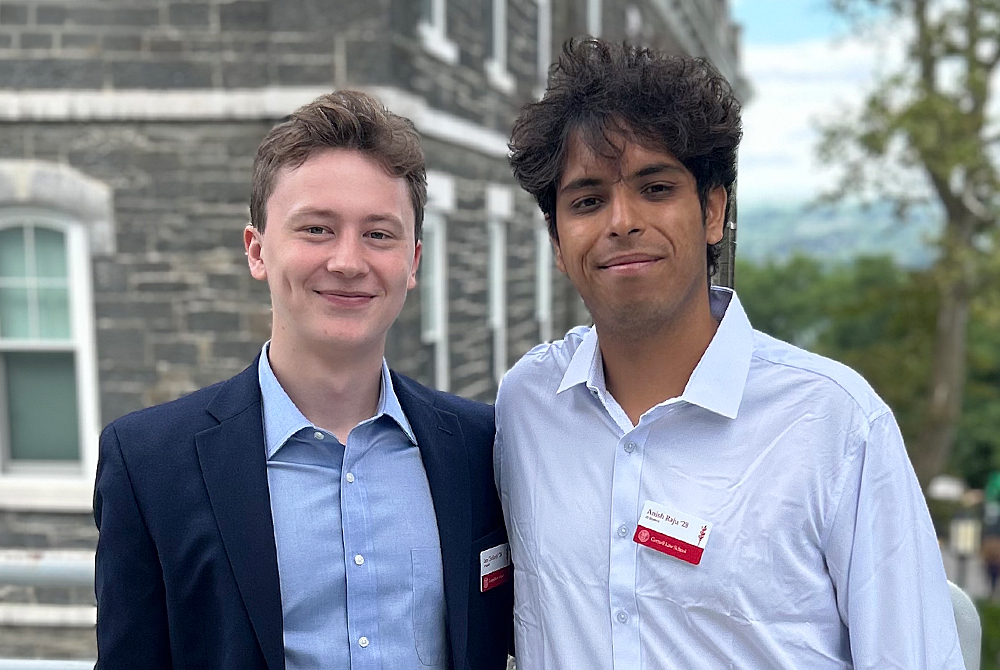 two students posing for photo outside