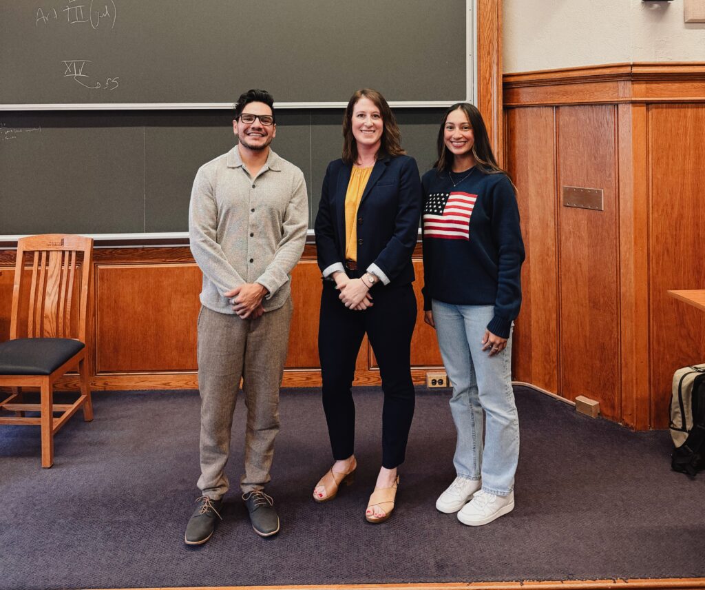 three peoplein front of a chalk board
