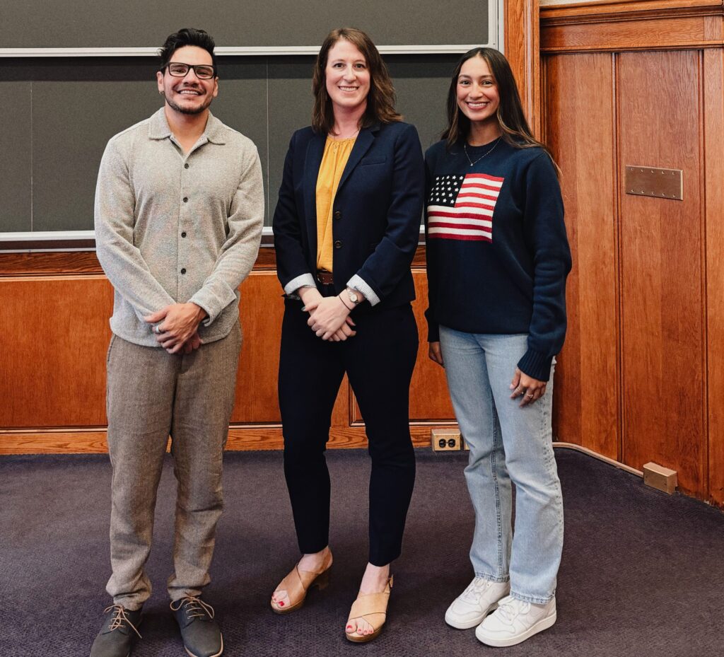 three peoplein front of a chalk board