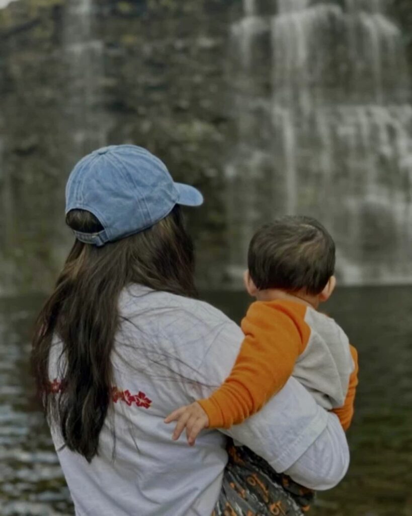 back of young woman holding a baby
