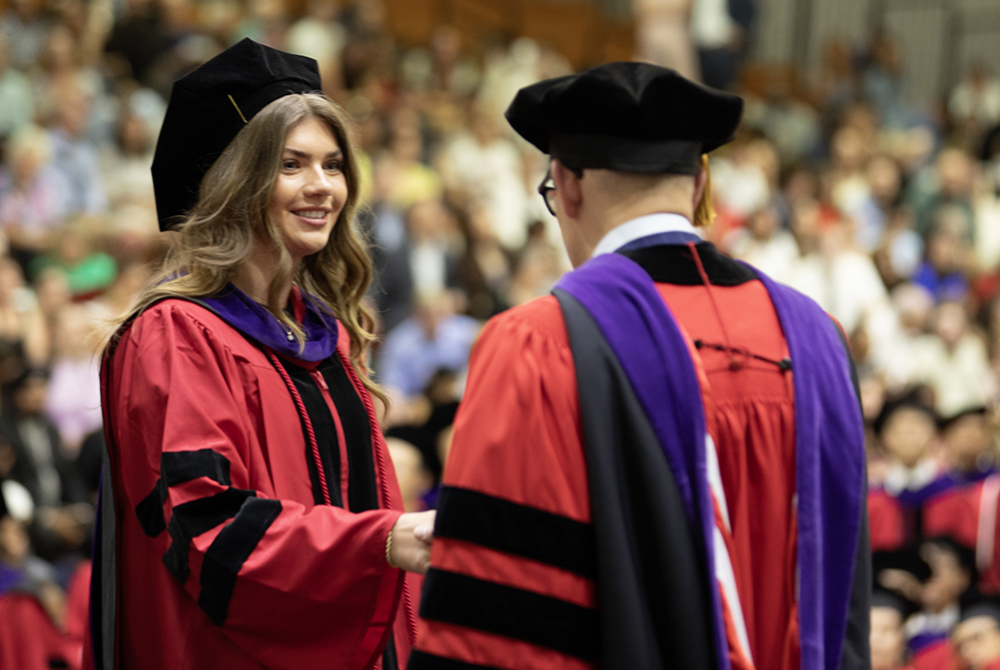 Dean Jens Ohlin with student walking the stage.