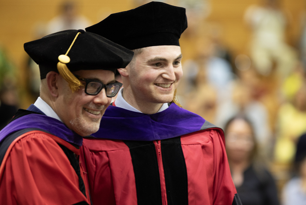 Dean Jens Ohlin and student crossing the stage.